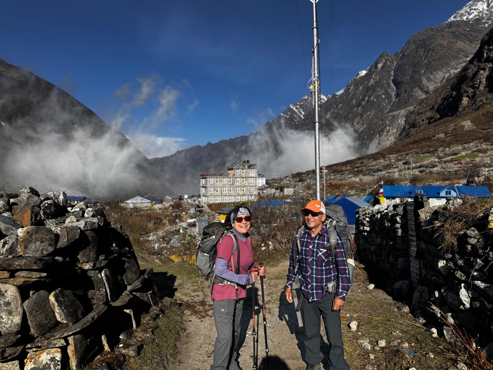 Walking into a stone village as cloud fills the valley