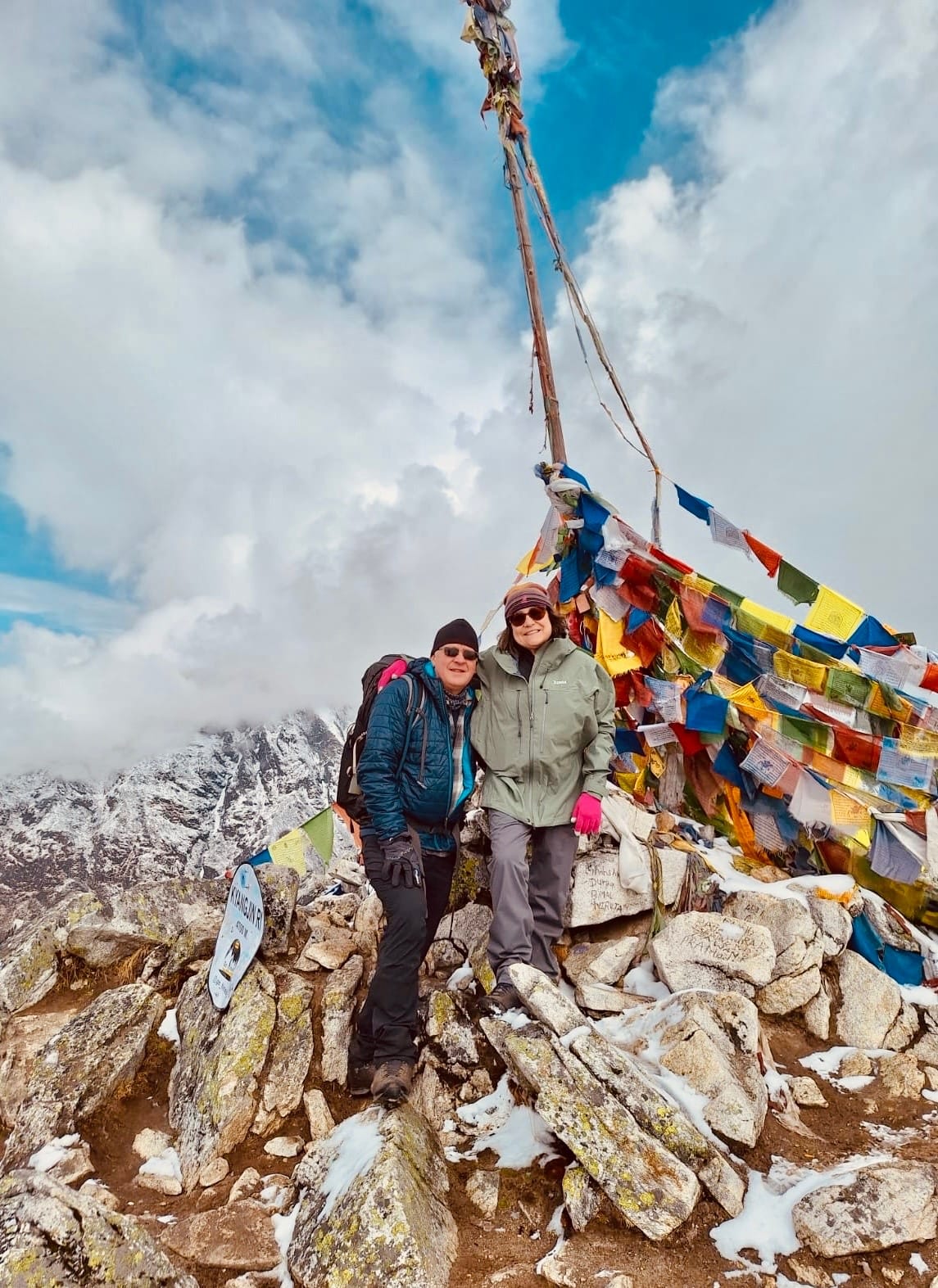 A pair among the prayer flags at the top of a pass